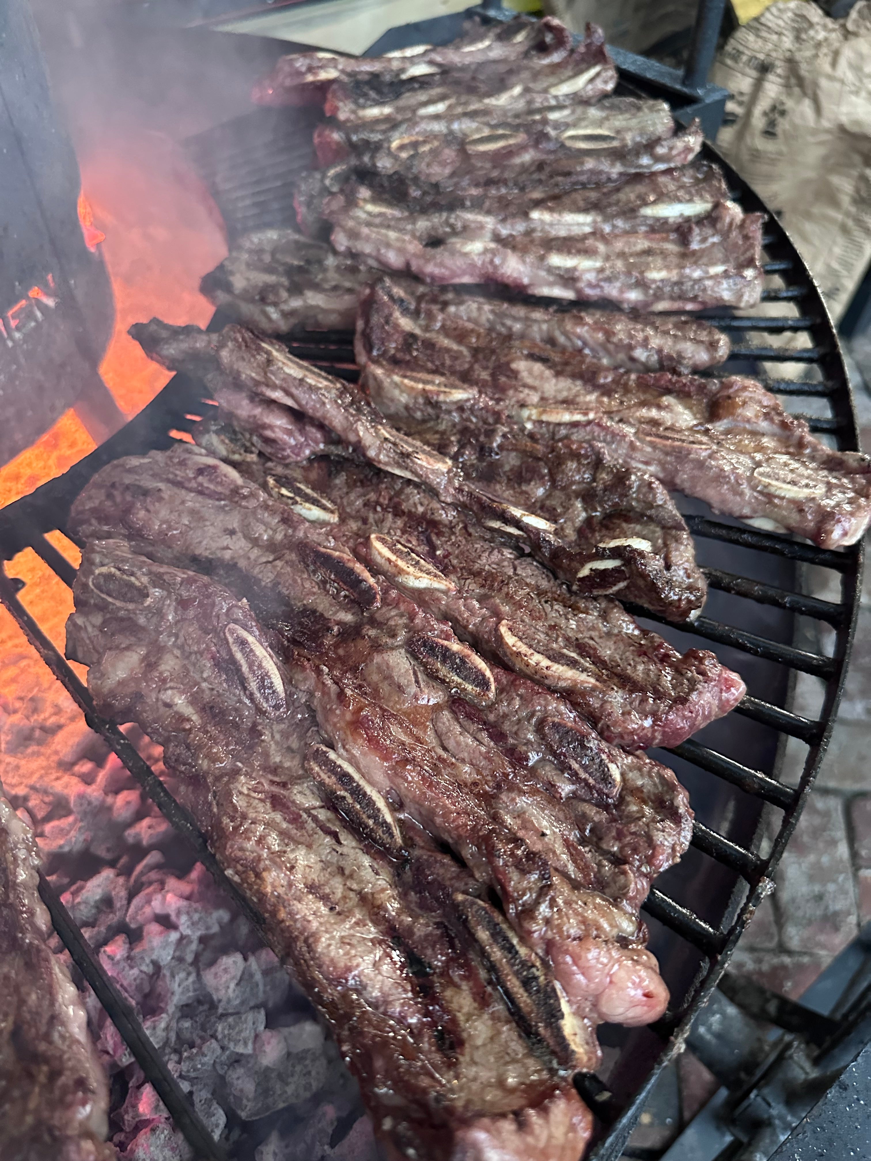 Ribs grilling on a barbecue with flames below